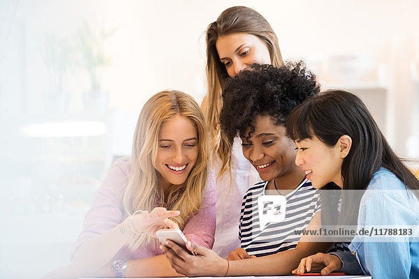 Junge Frauen  die gemeinsam auf das Smartphone schauen