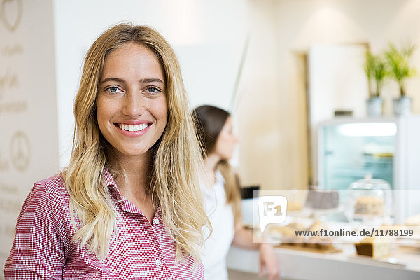 Young woman smiling cheerfully in bakery  portrait
