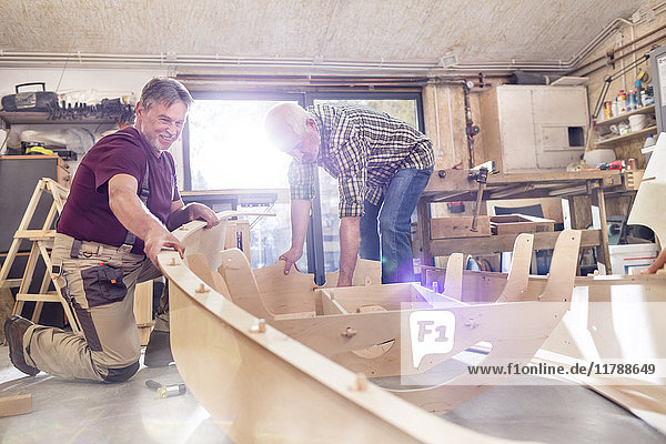 Männliche Schreiner  die in der Werkstatt Holzboote herstellen