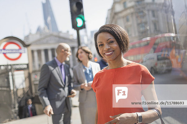 Porträt einer lächelnden Geschäftsfrau auf einer sonnigen städtischen Straße  London  UK