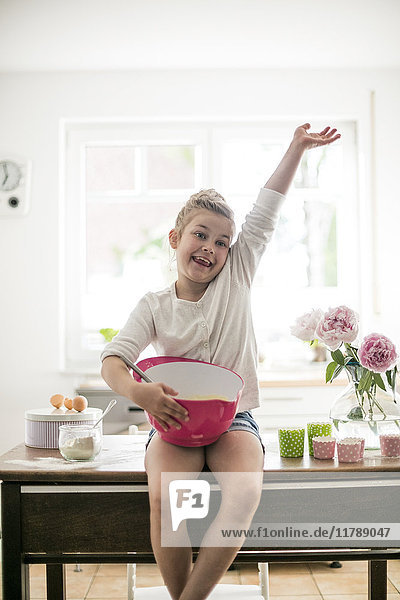 Stolzes kleines Mädchen beim Backen in der Küche