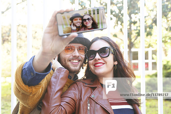 Happy young couple taking selfie with smartphone