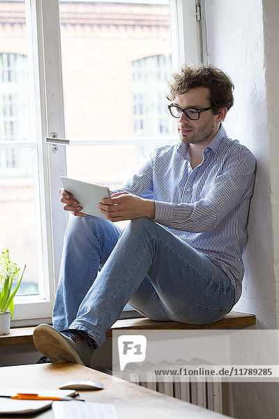 Man using tablet at the window in office