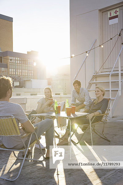 Freunde bei einer Dachparty an einem schönen Sommerabend