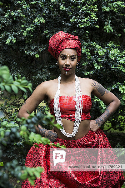 Porträt einer jungen Frau mit Piercings und Tatoos in traditioneller brasilianischer Kleidung