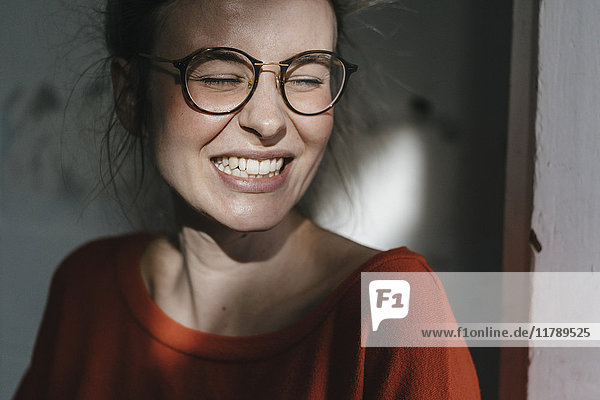 Porträt einer glücklichen jungen Frau mit Brille
