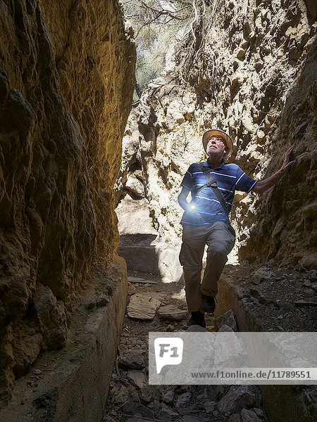 Spanien  Sierra Nevada  Laujar de Andarax  älterer Mann beim Erkunden des alten Wasserkanals