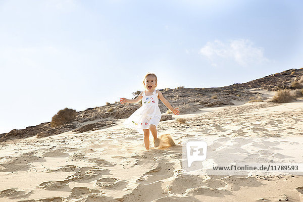 Spain  Fuerteventura  girl running down dune on the beach