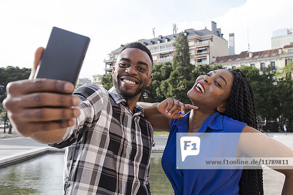 Porträt eines glücklichen jungen Paares  das sich selbst mit dem Handy fotografiert.