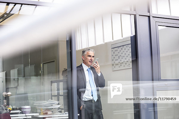 Reife Geschäftsleute im Büro mit Smartphone