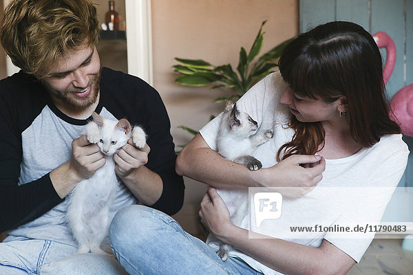 Young couple with kittens at home