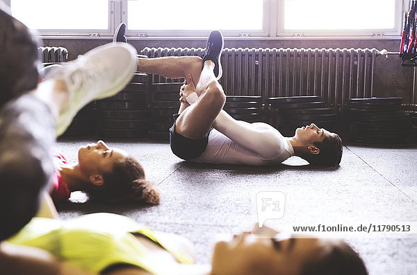 Drei junge Leute trainieren im Fitnessstudio