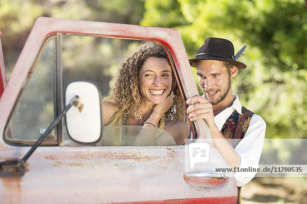 Fröhliches junges Paar beim alten Pickup