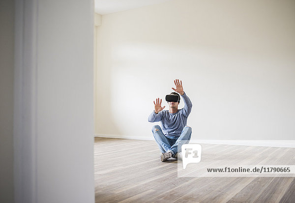 Man in empty apartment wearing VR glasses