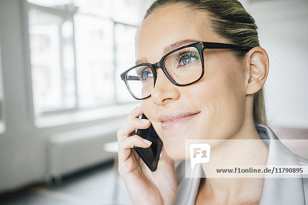 Porträt einer lächelnden Geschäftsfrau am Telefon