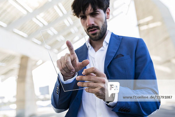 Young businessman using futuristic portable device