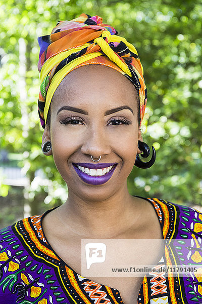 Porträt einer glücklichen jungen Frau mit Piercings in traditioneller brasilianischer Kleidung