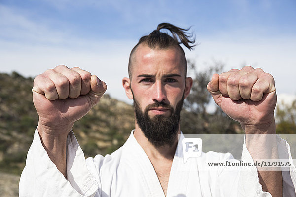 Portrait of man doing martial arts pose outdoors