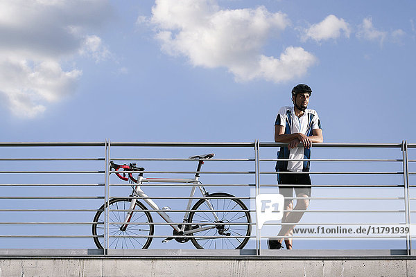 Junger Mann mit Rennrad in der Pause