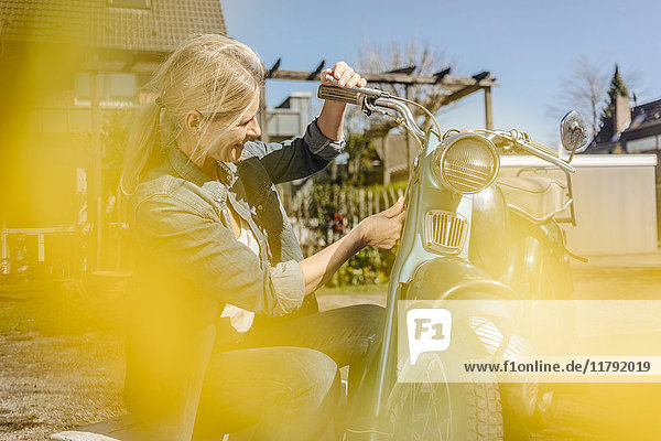 Lächelnde Frau mit Oldtimer-Motorrad