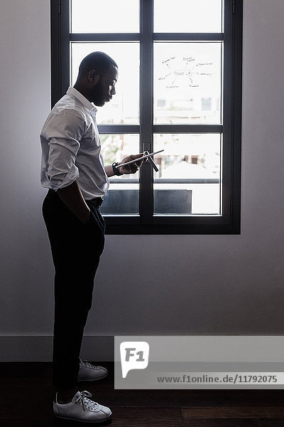 Businessman holding tablet at the window