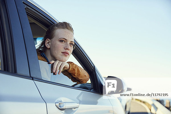 Young woman looking out of a car