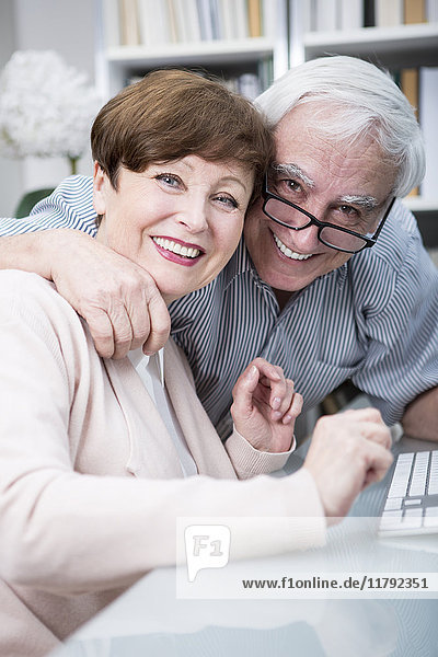 Senior couple embracing and smiling at camera