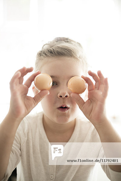 Porträt eines kleinen Mädchens mit zwei braunen Eiern