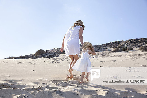 Spain  Fuerteventura  mother walking with daughter on the beach