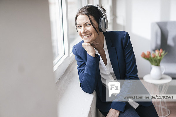 Porträt einer Frau  die Musik mit Kopfhörern hört