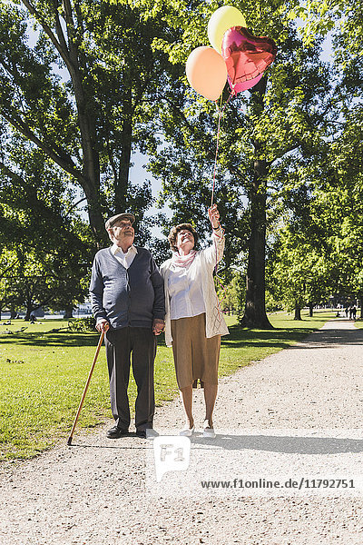 Senior couple with balloons in a park