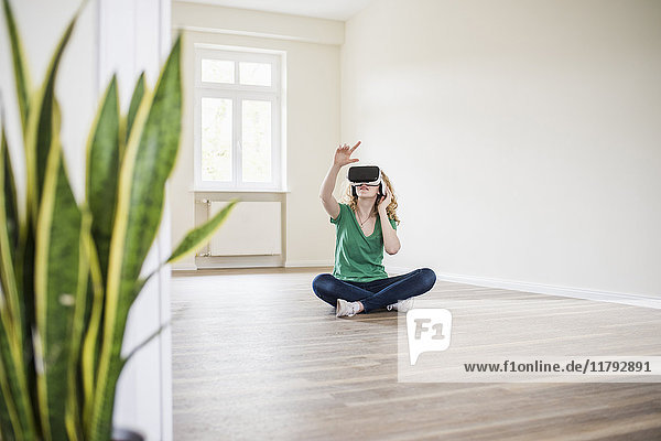 Frau in leerer Wohnung mit VR-Brille