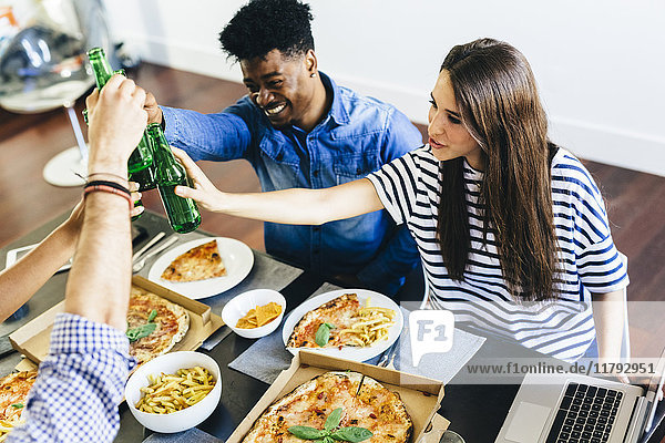 Gruppe von Freunden bei Pizza und Bier zu Hause