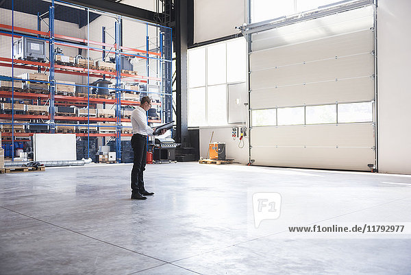 Man with documents on factory shop floor