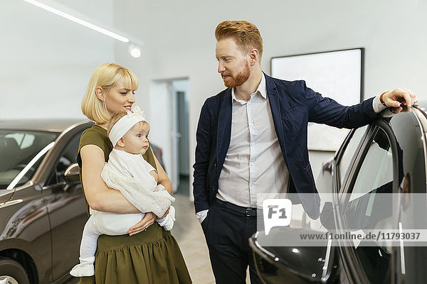 Familie im Autohaus bei der Wahl des Familienfahrzeuges