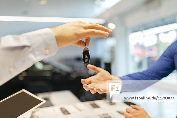 Verkäufer übergibt Autoschlüssel an den Kunden