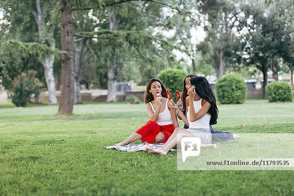 Friends in a park enjoying popsicles