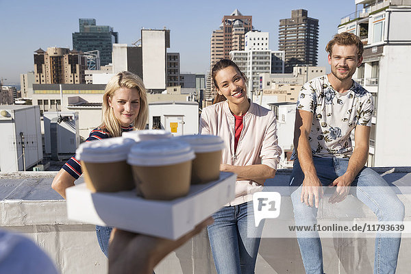 Friends drinking coffee on a rooftop terrace