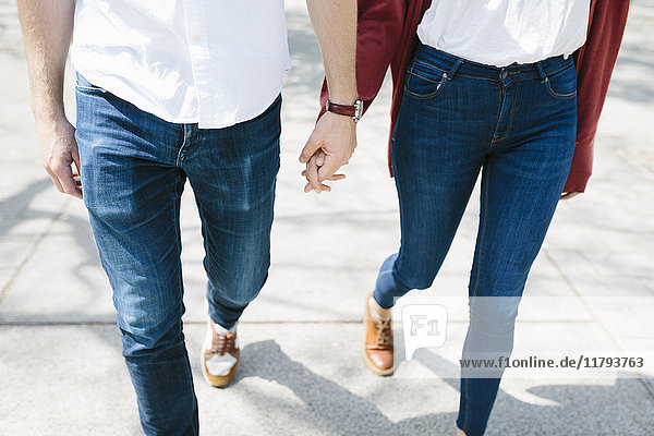 Glückliches Paar auf der Straße  Händchen haltend  niedriger Abschnitt