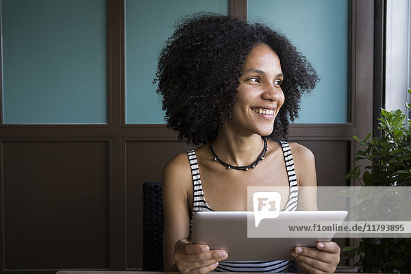 Lächelnde junge Frau mit Tablette im Coffee-Shop