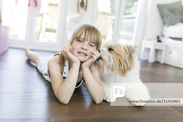 Girl with dog lying on the floor at home