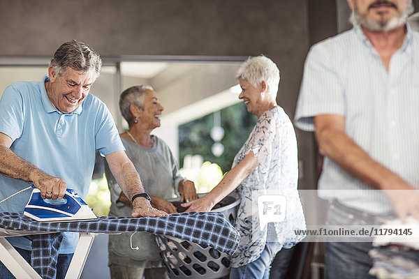 Senioren bügeln Kleidung zusammen