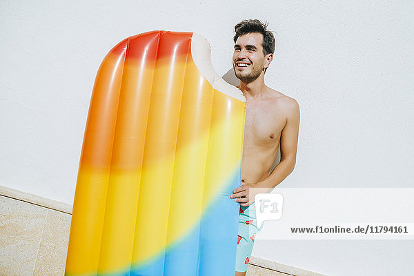 Man with ice cream float in front of white wall