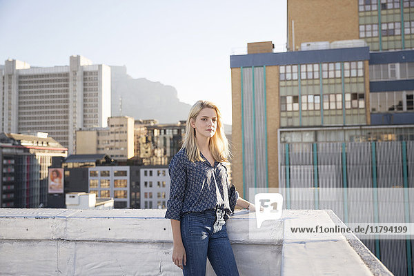 Young woman standing on a rooftop terrace