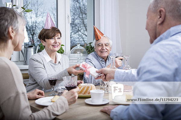 Zwei Seniorenpaare feiern Geburtstag  Toast mit Rotwein