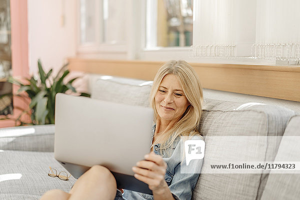Woman at home on couch with tablet