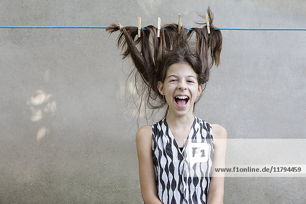 Brunette girl's hair drying on clothesline
