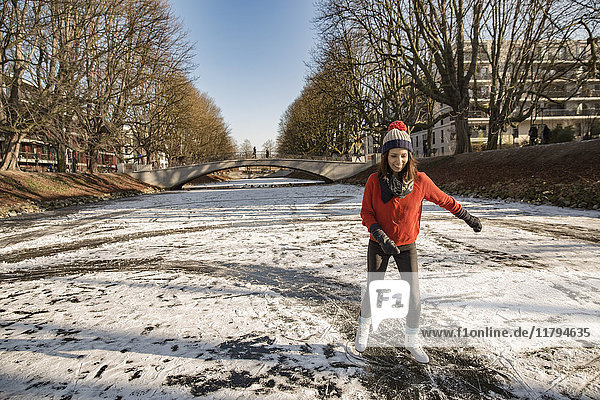 Woman ice skating on canal