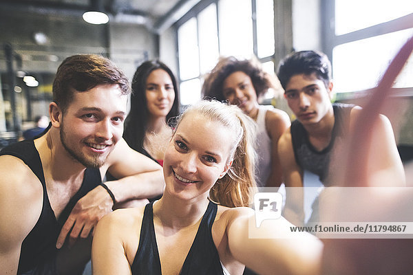 Gruppe junger Leute  die für einen Selfie im Fitnessstudio posieren