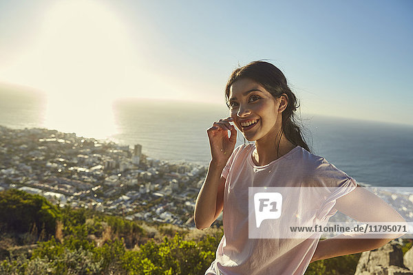 Südafrika  Kapstadt  Signal Hill  Portrait der lächelnden jungen Frau über der Stadt